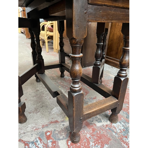 151 - A Georgian oak drop leaf gate leg oval dining table - approx. 74cm high x 109cm wide x 153cm long