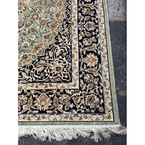 206 - A Middle Eastern green floral pattern rug - approx. 185cm x 133cm