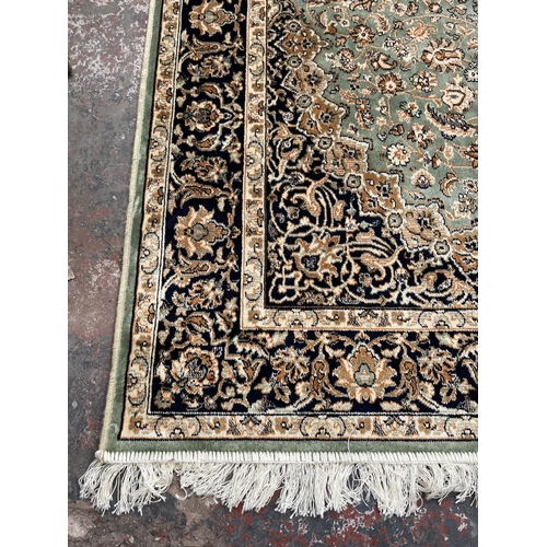 206 - A Middle Eastern green floral pattern rug - approx. 185cm x 133cm