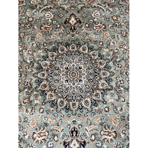 206 - A Middle Eastern green floral pattern rug - approx. 185cm x 133cm