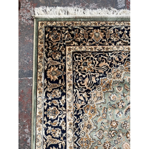 206 - A Middle Eastern green floral pattern rug - approx. 185cm x 133cm