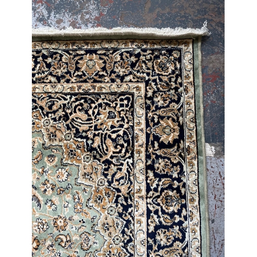 206 - A Middle Eastern green floral pattern rug - approx. 185cm x 133cm