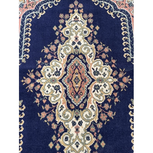 94 - A blue floral pattern rug - approx. 168cm x 121cm