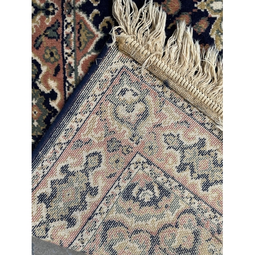 94 - A blue floral pattern rug - approx. 168cm x 121cm