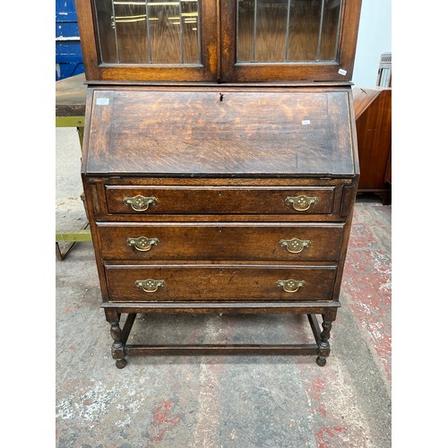 103A - An early 20th century oak bureau bookcase on barley twist supports - approx. 98cm high x 87cm wide x... 