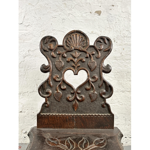 42 - A carved oak hall chair - approx. 84cm high x 39cm wide x 48cm deep