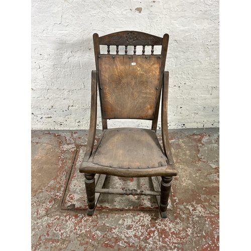 47 - An early 20th century beech rocking chair with spindle back and shell design