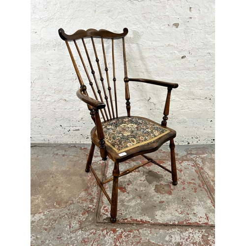 54 - An early 20th century beech and tapestry upholstered moustache armchair