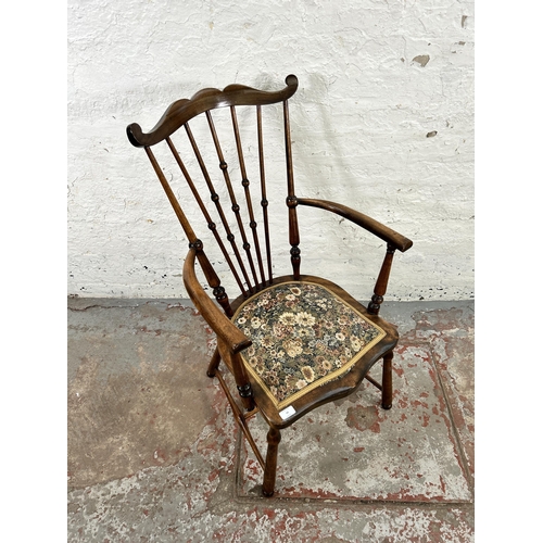 54 - An early 20th century beech and tapestry upholstered moustache armchair