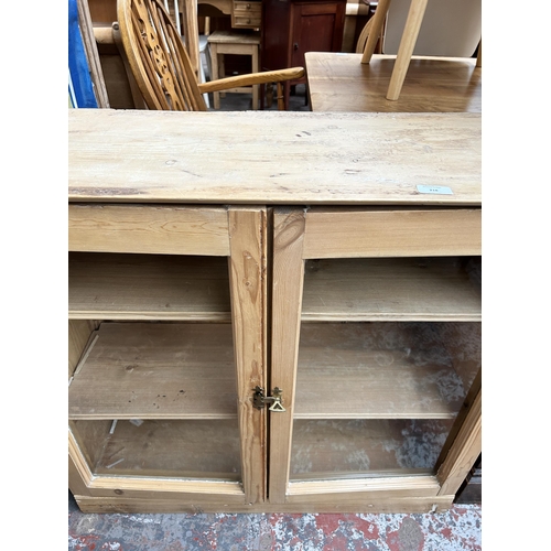 218 - A Victorian pine two door glazed bookcase - approx. 83cm high x 90cm wide x 33cm deep