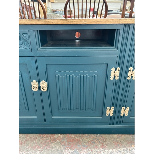 228 - A green painted oak linenfold sideboard converted TV stand - approx. 72cm high x 183cm wide x 47cm d... 