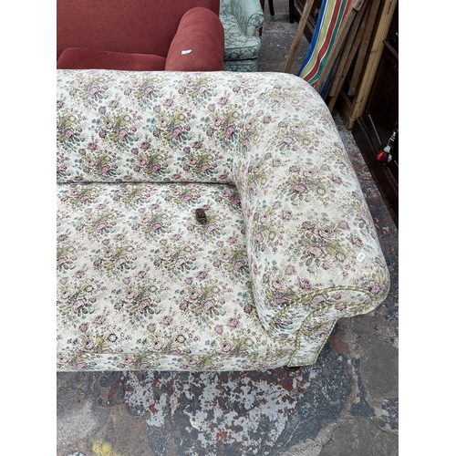 240 - A Victorian floral upholstered three seater sofa with turned wooden supports and castors - approx. 7... 