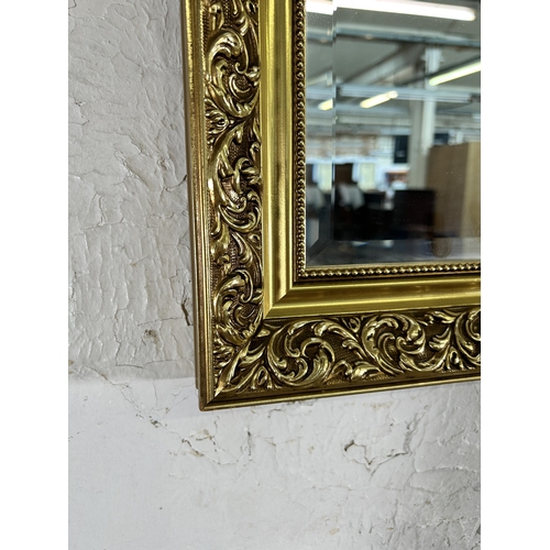 246 - A gilt framed bevelled edge wall mirror - approx. 71cm high x 101cm wide