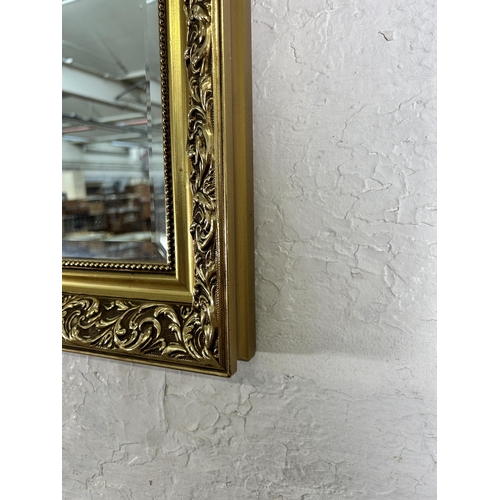 246 - A gilt framed bevelled edge wall mirror - approx. 71cm high x 101cm wide