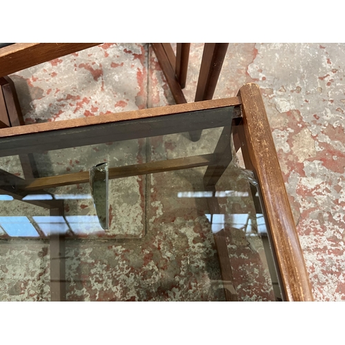 172 - A teak and smoked glass nest of three tables