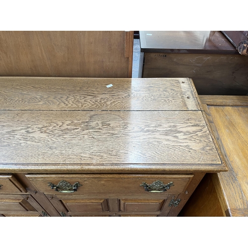 173 - An Arts & Crafts style panelled oak sideboard