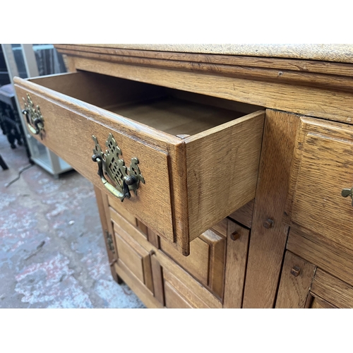 173 - An Arts & Crafts style panelled oak sideboard