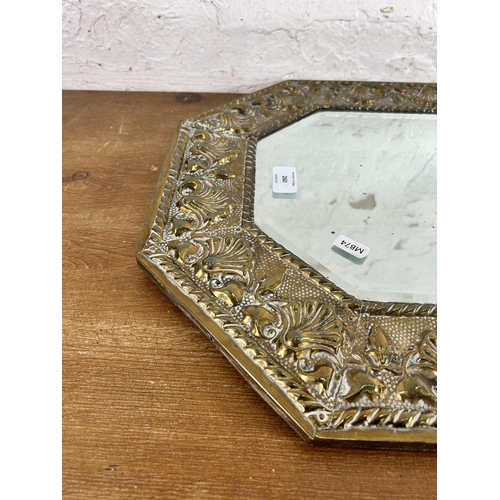 260 - A mid 20th century brass framed bevelled edge octagonal wall mirror with embossed shell design