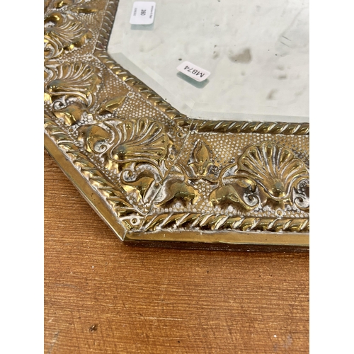 260 - A mid 20th century brass framed bevelled edge octagonal wall mirror with embossed shell design