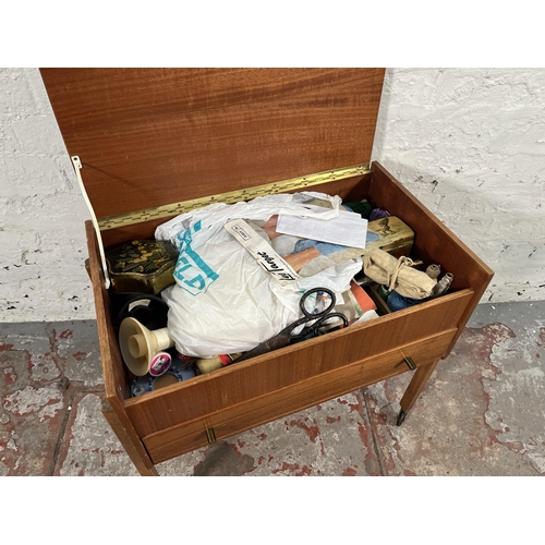 181 - A mid 20th century teak sewing table containing sewing accessories