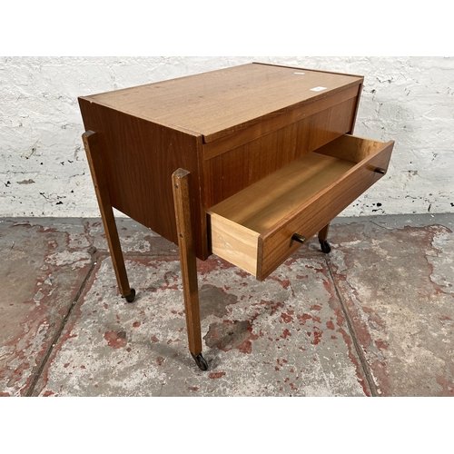 181 - A mid 20th century teak sewing table containing sewing accessories