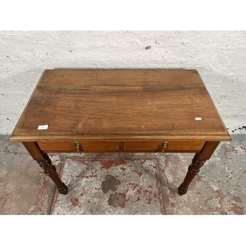 200 - A 19th century style walnut two drawer writing table with turned supports