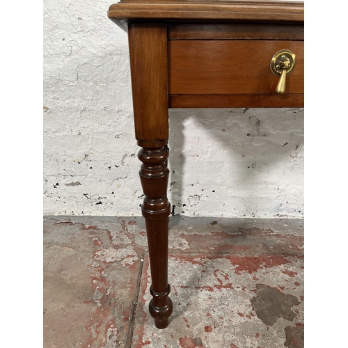 200 - A 19th century style walnut two drawer writing table with turned supports