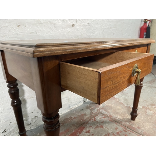 200 - A 19th century style walnut two drawer writing table with turned supports