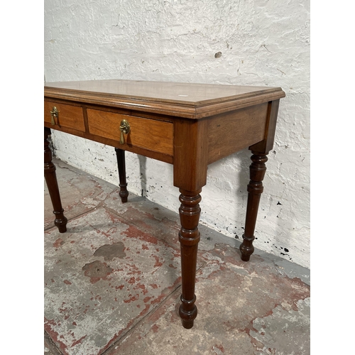 200 - A 19th century style walnut two drawer writing table with turned supports