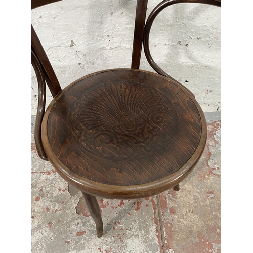 219 - An early 20th century bentwood armchair with embossed shell design