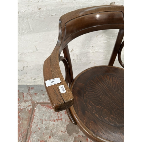 219 - An early 20th century bentwood armchair with embossed shell design