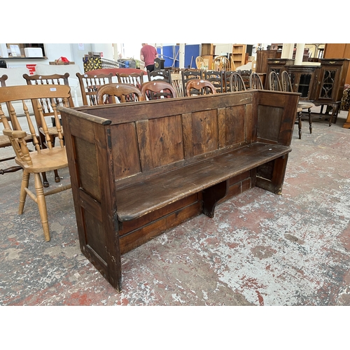 230 - An early 20th century pine church pew - approx. 85cm high x 165cm wide x 50cm deep