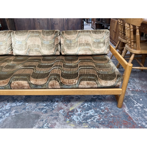 234 - A mid 20th century beech and fabric upholstered two piece lounge suite comprising three seater sofa ... 