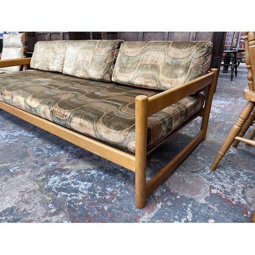 234 - A mid 20th century beech and fabric upholstered two piece lounge suite comprising three seater sofa ... 