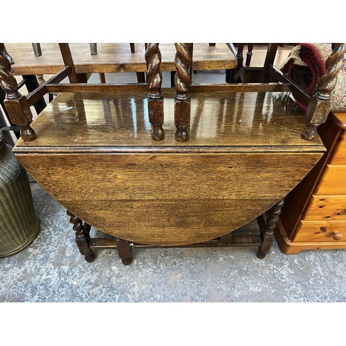 146 - An oak drop leaf gate leg oval dining table on barley twist supports and four dining chairs