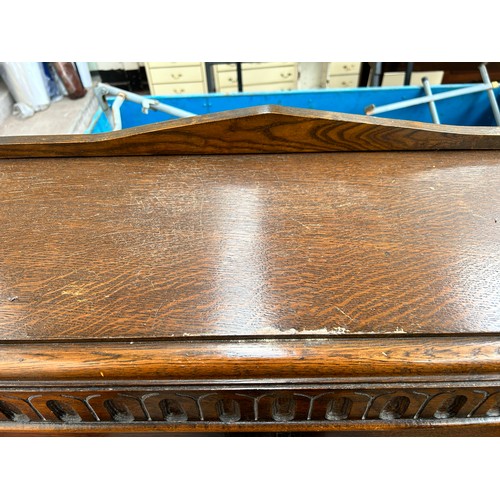 95 - A carved oak linenfold bookcase with two leaded glass doors