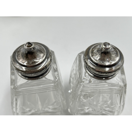 302 - Three pieces of cut glassware with hallmarked sterling silver tops, two salt and pepper shakers and ... 