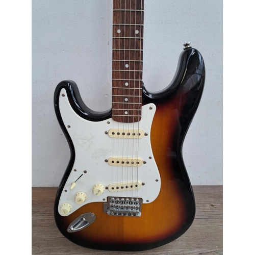 635 - Two items, one cased left handed 2005 Squier Stratocaster electric guitar with two electronic tuners... 