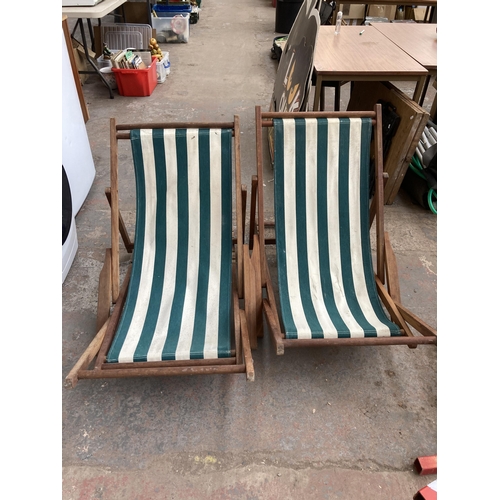 883 - A pair of teak and cloth folding sun loungers