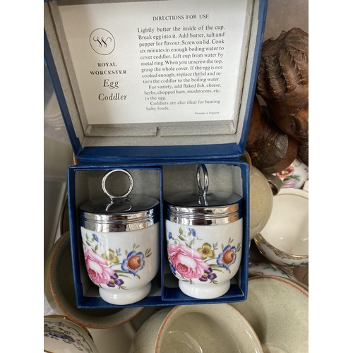 943 - A box containing boxed pair of Royal Worcester egg coddlers, treenware, silver plated ware, Denby Da... 