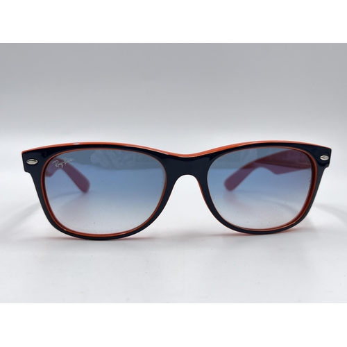 2296 - A cased pair of Ray-Ban New Wayfarer Luxottica sunglasses