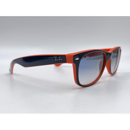 2296 - A cased pair of Ray-Ban New Wayfarer Luxottica sunglasses