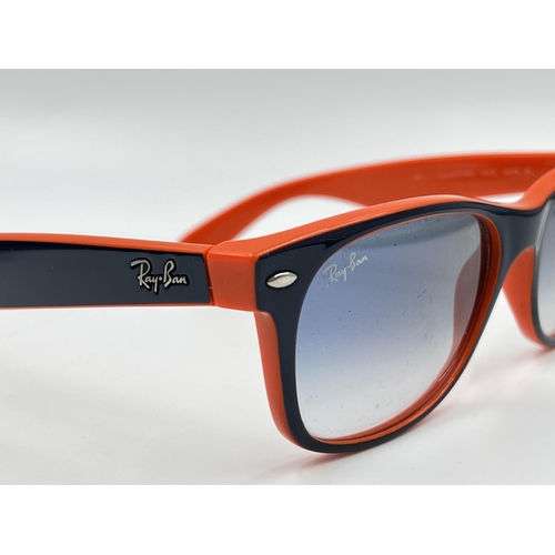 2296 - A cased pair of Ray-Ban New Wayfarer Luxottica sunglasses