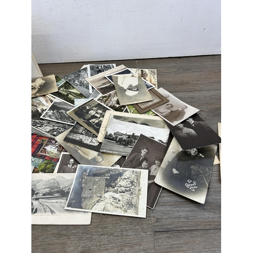 480 - A collection of 19th century and later black and white postcards and photographs