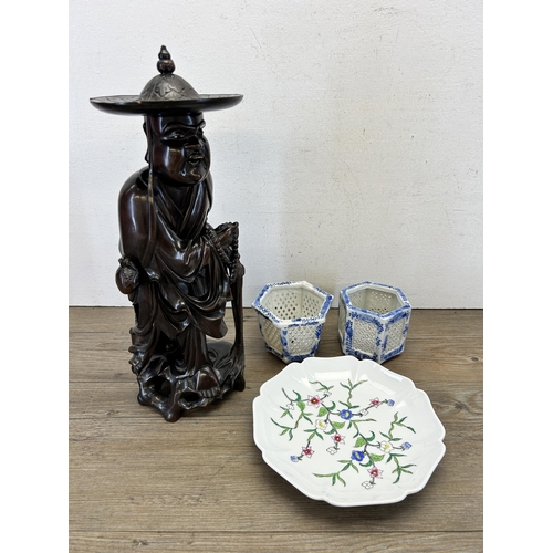 517 - Four Oriental items - one carved hardwood priest figurine, two blue and white ceramic pierced cricke... 