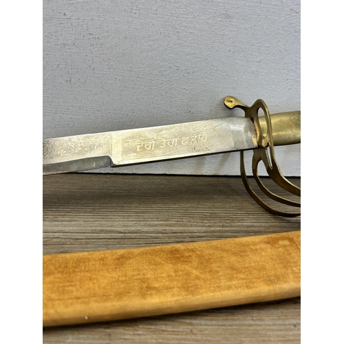 555 - An Indian cutlass sword with brass lion design handle and scabbard - approx. 88cm long including han... 