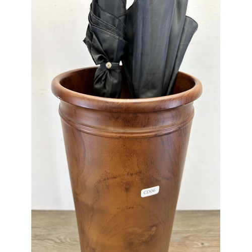 558 - A yew wood cylindrical stick stand with two umbrellas - approx. 59cm high x 20cm diameter