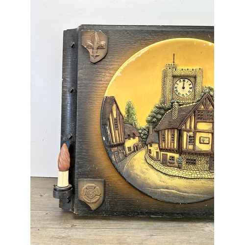 559 - A mid 20th century hand painted chalkware illuminating wall clock depicting village scene - approx. ... 