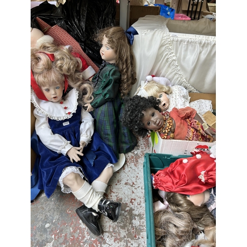 931 - A large collection of porcelain dolls together with cot and games