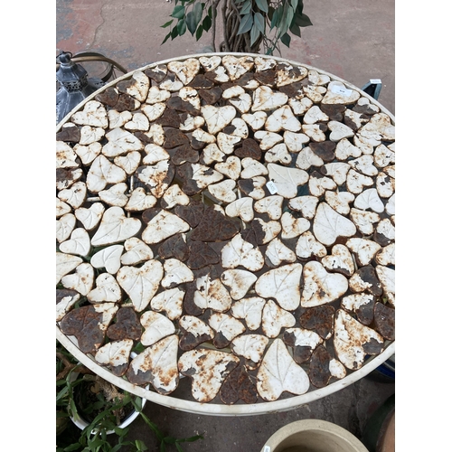 878 - A wrought metal folding patio table with foliate design - approx. 74cm high x 70cm diameter